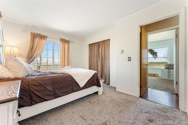 carpeted bedroom with crown molding and baseboards