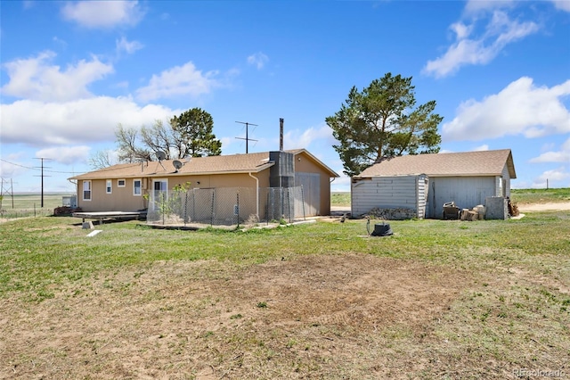 rear view of house with fence and a yard