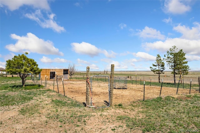view of yard featuring a rural view, an outbuilding, and fence