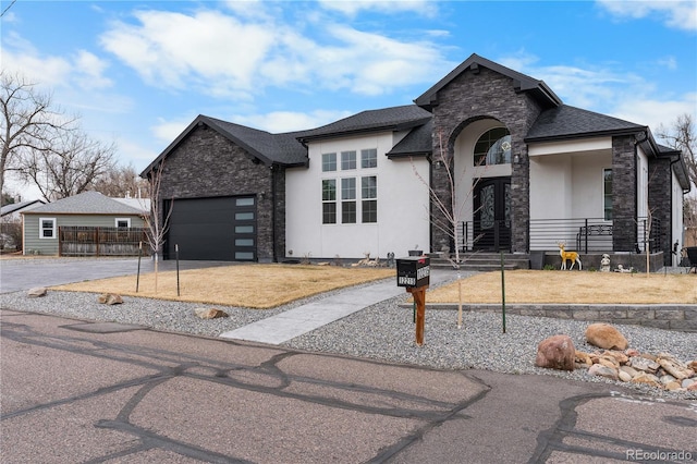 view of front of house featuring stone siding, stucco siding, concrete driveway, and a garage