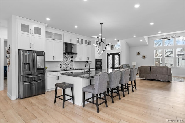 12215 Viewpoint Dr, Lakewood, CO 80401 - kitchen with a breakfast bar area, decorative backsplash, stainless steel refrigerator with ice dispenser, exhaust hood, and a sink