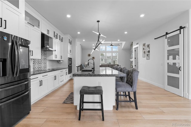 12215 Viewpoint Dr, Lakewood, CO 80401 - kitchen with open floor plan, a breakfast bar area, a barn door, range hood, and stainless steel fridge