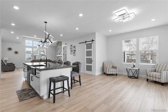 12215 Viewpoint Dr, Lakewood, CO 80401 - kitchen with light wood-style floors, open floor plan, a kitchen bar, and a barn door