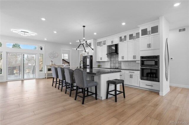 12215 Viewpoint Dr, Lakewood, CO 80401 - kitchen with tasteful backsplash, visible vents, multiple ovens, range hood, and a kitchen breakfast bar
