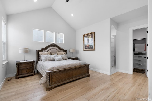 12215 Viewpoint Dr, Lakewood, CO 80401 - bedroom with baseboards, lofted ceiling, light wood-style floors, and a walk in closet