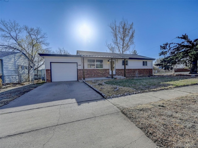 2601 Cooper Ave, Colorado Springs, CO 80907 - ranch-style house with brick siding, an attached garage, concrete driveway, and fence