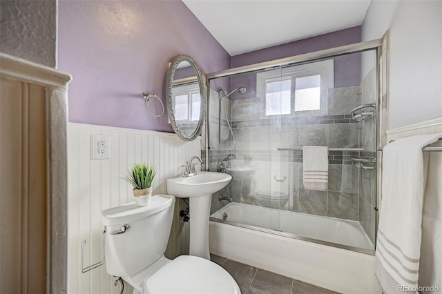 2601 Cooper Ave, Colorado Springs, CO 80907 - bathroom featuring wainscoting, toilet, and enclosed tub / shower combo