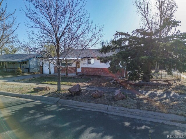 2601 Cooper Ave, Colorado Springs, CO 80907 - view of front of house with driveway, a garage, and brick siding