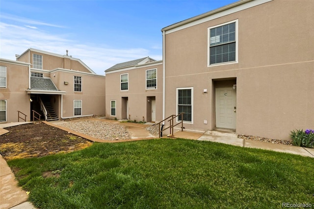 3110 Van Teylingen Dr Unit C, Colorado Springs, CO 80917 - back of house with stucco siding, stairway, and a lawn