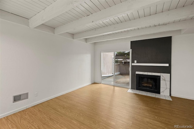 3110 Van Teylingen Dr Unit C, Colorado Springs, CO 80917 - unfurnished living room featuring wood finished floors, a tiled fireplace, wood ceiling with exposed beams, and baseboards