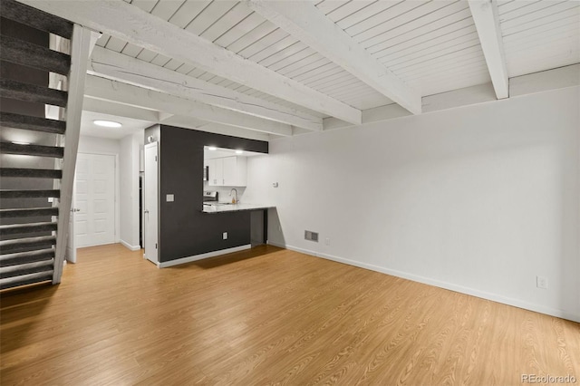 3110 Van Teylingen Dr Unit C, Colorado Springs, CO 80917 - unfurnished living room featuring stairs, baseboards, wood ceiling with exposed beams, light wood finished floors, and a sink