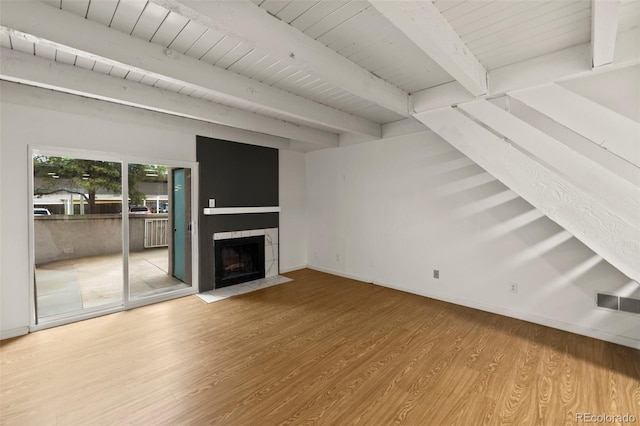 3110 Van Teylingen Dr Unit C, Colorado Springs, CO 80917 - unfurnished living room with wood finished floors, baseboards, a tiled fireplace, and wood ceiling with exposed beams