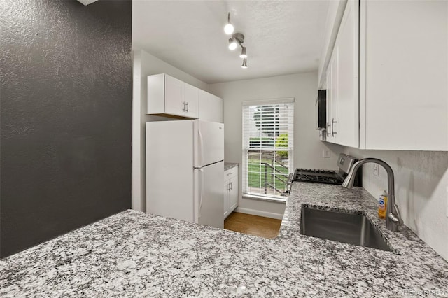 3110 Van Teylingen Dr Unit C, Colorado Springs, CO 80917 - kitchen featuring freestanding refrigerator, a sink, gas range, light stone countertops, and white cabinets