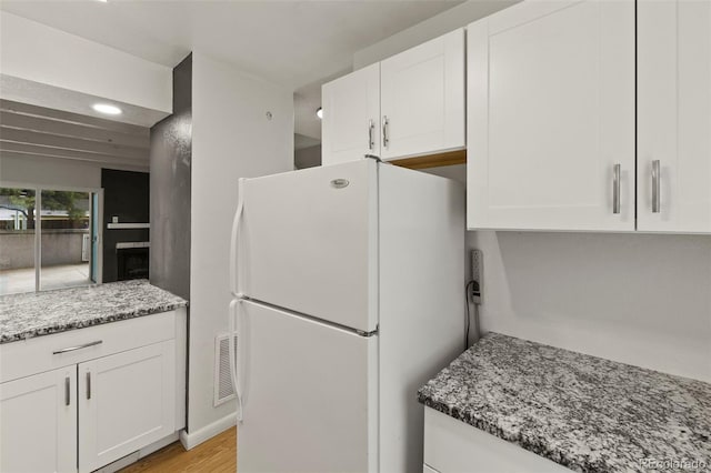 3110 Van Teylingen Dr Unit C, Colorado Springs, CO 80917 - kitchen with freestanding refrigerator, white cabinets, stone counters, recessed lighting, and light wood-style floors