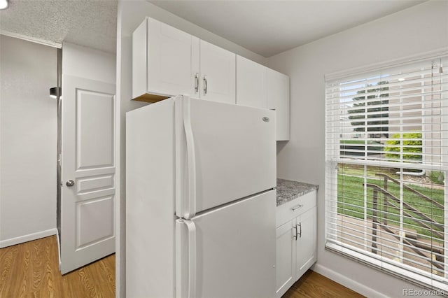 3110 Van Teylingen Dr Unit C, Colorado Springs, CO 80917 - kitchen featuring freestanding refrigerator, light wood finished floors, and white cabinets