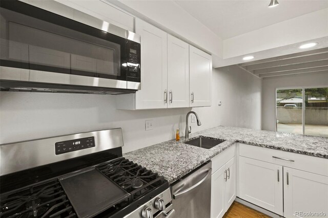3110 Van Teylingen Dr Unit C, Colorado Springs, CO 80917 - kitchen with stainless steel appliances, a sink, white cabinetry, light stone countertops, and recessed lighting