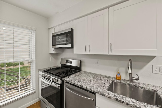 3110 Van Teylingen Dr Unit C, Colorado Springs, CO 80917 - kitchen with stainless steel appliances, a sink, plenty of natural light, and white cabinetry