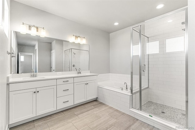 bathroom featuring vanity and independent shower and bath