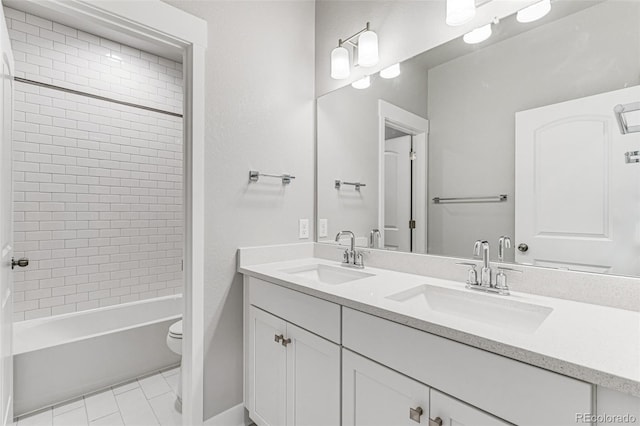 full bathroom featuring vanity, tile patterned flooring, toilet, and tiled shower / bath