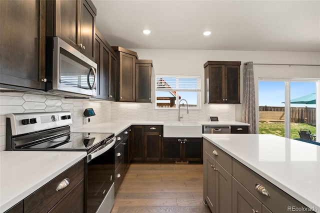 208 Dorothy Dr, Berthoud, CO 80513 - kitchen with tasteful backsplash, light countertops, appliances with stainless steel finishes, light wood finished floors, and a sink