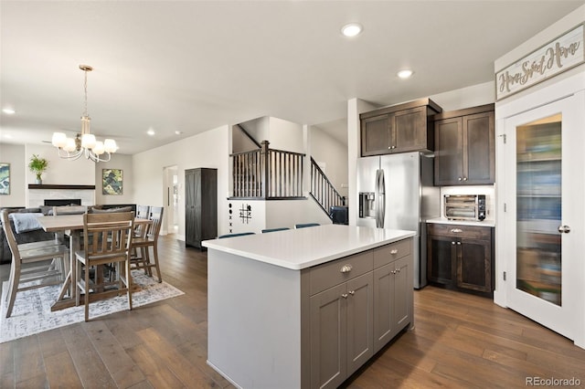 208 Dorothy Dr, Berthoud, CO 80513 - kitchen with dark wood finished floors, light countertops, an inviting chandelier, and stainless steel fridge