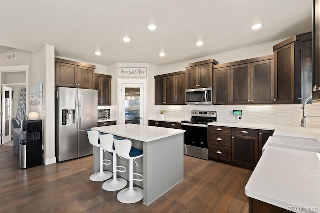 208 Dorothy Dr, Berthoud, CO 80513 - kitchen with dark wood-type flooring, a center island, dark brown cabinets, and appliances with stainless steel finishes