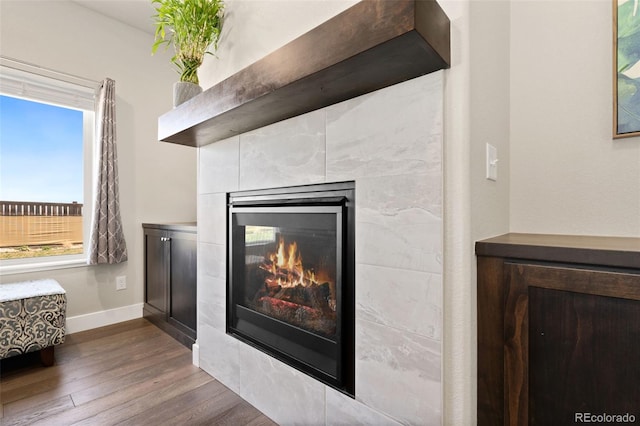 208 Dorothy Dr, Berthoud, CO 80513 - room details featuring a tile fireplace, baseboards, and wood finished floors