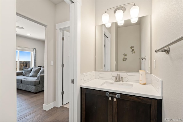208 Dorothy Dr, Berthoud, CO 80513 - bathroom featuring baseboards, ensuite bath, vanity, wood finished floors, and backsplash
