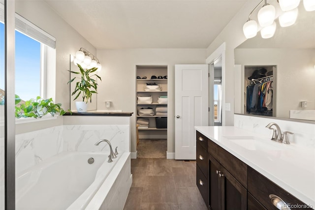 208 Dorothy Dr, Berthoud, CO 80513 - bathroom featuring a bath, vanity, a walk in closet, and a wealth of natural light