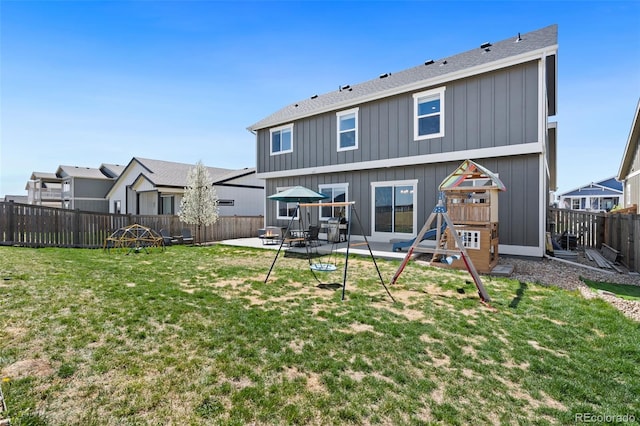 208 Dorothy Dr, Berthoud, CO 80513 - rear view of property featuring board and batten siding, a patio area, a fenced backyard, a yard, and a playground