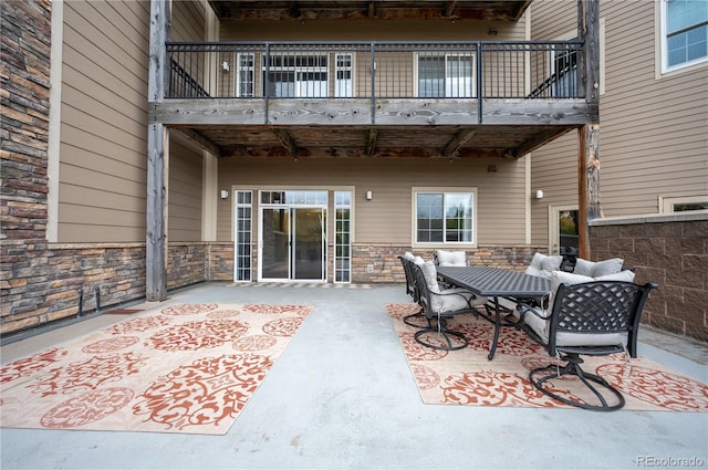 view of patio featuring a balcony and outdoor dining space