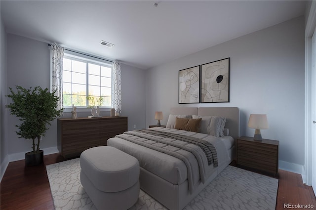 bedroom featuring visible vents, baseboards, and wood finished floors