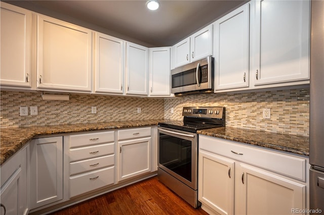 kitchen with appliances with stainless steel finishes, dark wood-style flooring, white cabinetry, and decorative backsplash