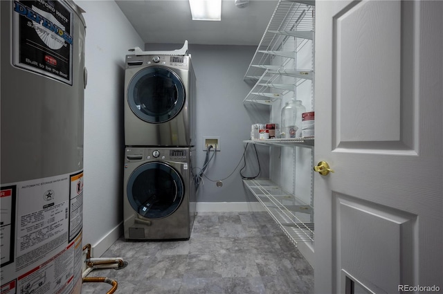 laundry room featuring stacked washer / dryer, laundry area, water heater, and baseboards