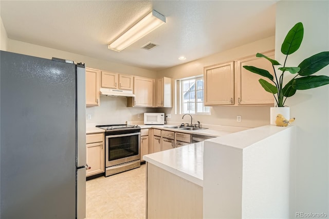 kitchen with a textured ceiling, light brown cabinets, sink, and stainless steel appliances