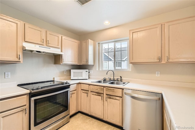 kitchen with appliances with stainless steel finishes, light brown cabinetry, and sink