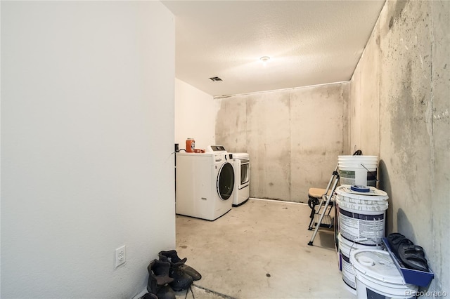 laundry room featuring separate washer and dryer and a textured ceiling