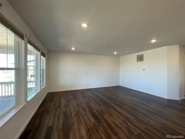 unfurnished room featuring dark wood-style floors, recessed lighting, visible vents, and baseboards