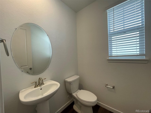 bathroom featuring baseboards, a sink, and toilet