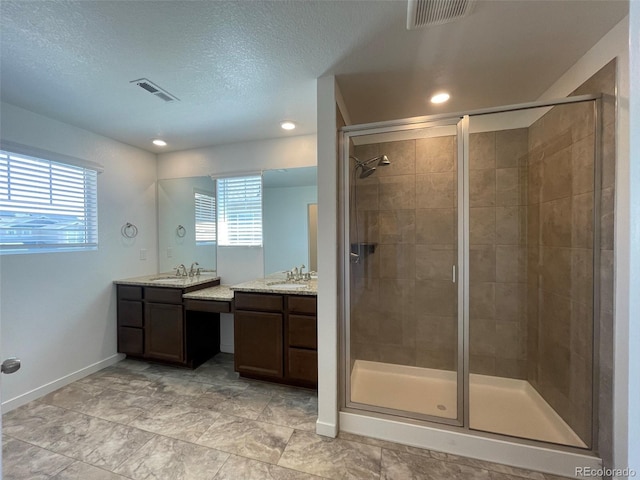 bathroom with a shower stall, visible vents, and a sink