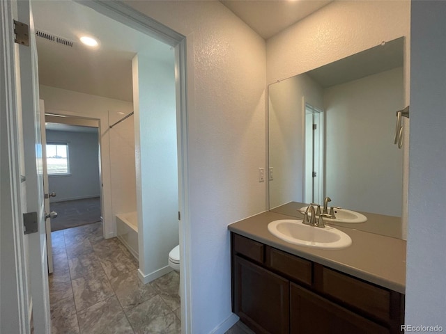 bathroom with baseboards, visible vents, toilet, tub / shower combination, and vanity