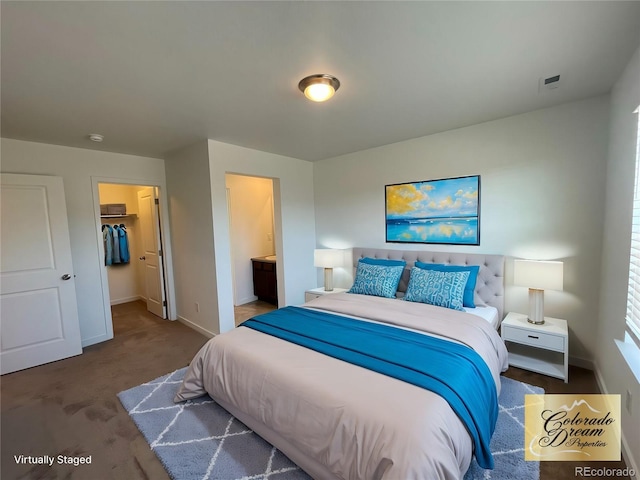 bedroom with carpet flooring, connected bathroom, a spacious closet, and baseboards