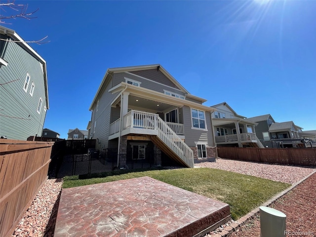 rear view of house featuring a patio area, fence, a lawn, and stairs