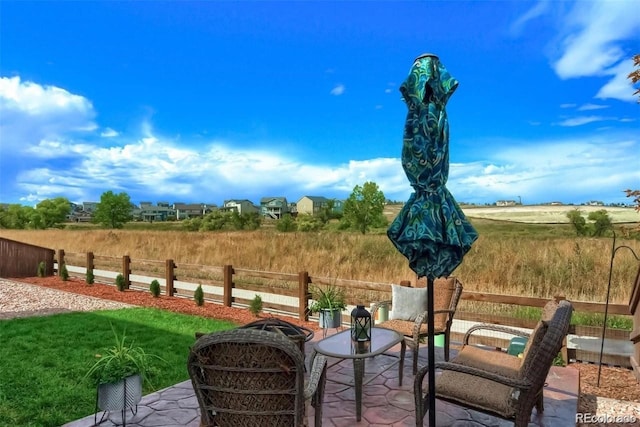 view of patio with a rural view and fence