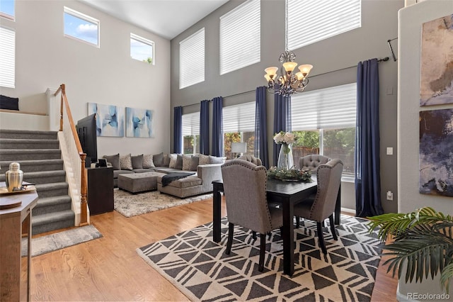 5301 Clovervale Cir, Highlands Ranch, CO 80130 - dining space featuring a chandelier, wood finished floors, stairway, and a towering ceiling