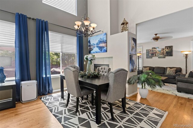5301 Clovervale Cir, Highlands Ranch, CO 80130 - dining room featuring a chandelier, wood finished floors, baseboards, a ceiling fan, and a towering ceiling