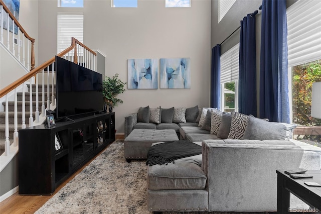 5301 Clovervale Cir, Highlands Ranch, CO 80130 - living room featuring a towering ceiling, plenty of natural light, stairway, wood finished floors, and baseboards