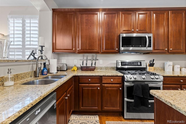 5301 Clovervale Cir, Highlands Ranch, CO 80130 - kitchen with stainless steel appliances, a sink, light stone countertops, and light wood-style flooring