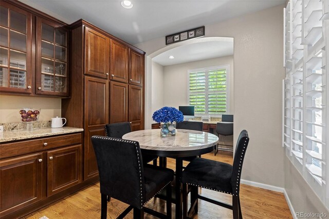 5301 Clovervale Cir, Highlands Ranch, CO 80130 - dining room with arched walkways, light wood-style flooring, baseboards, and recessed lighting