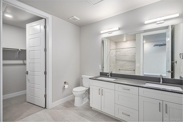 bathroom with tiled shower, vanity, tile patterned floors, and toilet